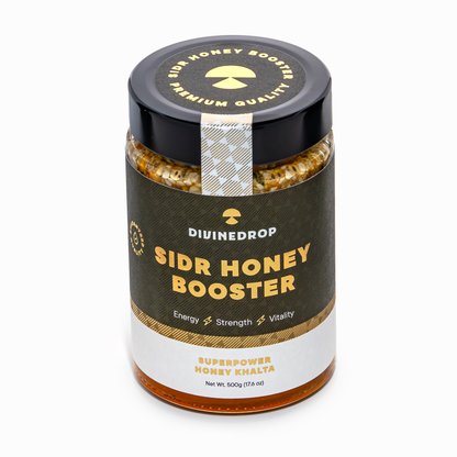 A jar of DIVINEDROP Sidr Honey Booster on a clean white background. The product features a black lid with gold lettering, a dark olive-green label with gold and white text, and a white lower section.